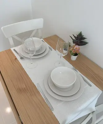 a wooden table with plates and glasses on it at Tranquil Studio in Damac Hills in Dubai