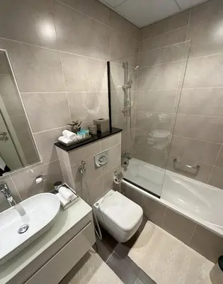 a bathroom with a sink and a toilet and a shower at Tranquil Studio in Damac Hills in Dubai