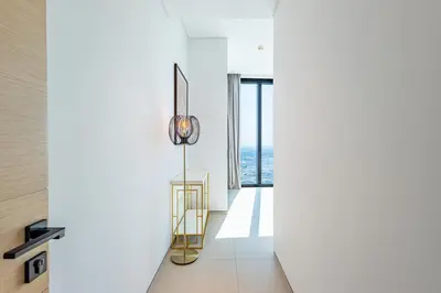 a room with white walls and a hallway with a surfboard at Address JBR: Beachfront Bliss & Sky-high Luxury in Dubai