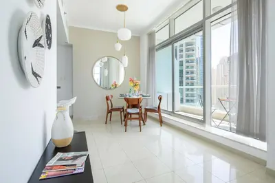a dining room with a table and a large window at Frank Porter - Botanica Tower 1 in Dubai