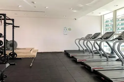 a gym with rows of tread machines in a room at Frank Porter - Botanica Tower 1 in Dubai