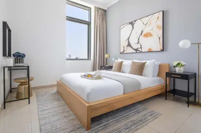 a bedroom with a large bed and a window at Frank Porter - Botanica Tower 1 in Dubai