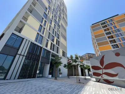 a building in a city with two tall buildings at Enchanting Studio at Mesk 1 Midtown Dubai Production City by Deluxe Holiday Homes in Dubai