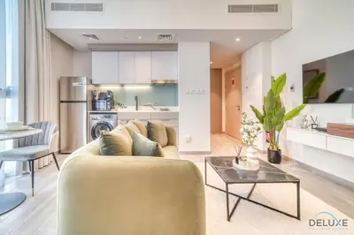 a living room with a couch and a table at Upscale Studio at Mesk 1 Midtown Dubai Production City by Deluxe Holiday Homes in Dubai