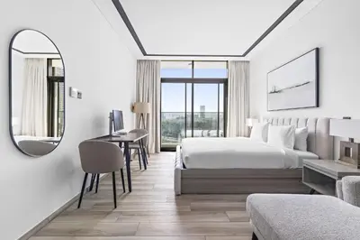 a bedroom with a bed and a desk and a mirror at ALiving Luxury Studio I Nicholas Residence, JVC in Dubai