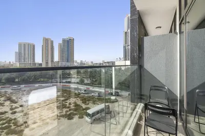a balcony with chairs and a view of a city at ALiving Luxury Studio I Nicholas Residence, JVC in Dubai
