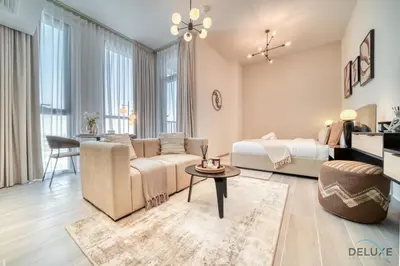 a living room with a couch and a bed at Tasteful Studio at Mesk 1 Midtown Dubai Production City by Deluxe Holiday Homes in Dubai