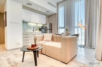 a living room with a couch and a table at Tasteful Studio at Mesk 1 Midtown Dubai Production City by Deluxe Holiday Homes in Dubai