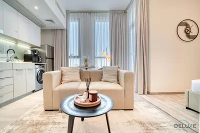 a living room with a couch and a table at Tasteful Studio at Mesk 1 Midtown Dubai Production City by Deluxe Holiday Homes in Dubai
