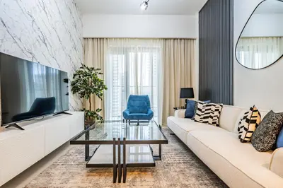a living room with a couch and a tv at Superior 1BR In Burj Royale - Downtown Dubai in Dubai