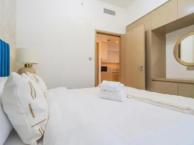 a white bed with white pillows and a mirror at Superior 1BR In Burj Royale - Downtown Dubai in Dubai