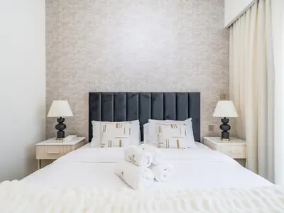 a bedroom with a large white bed with towels on it at Pleasant 1BR in Burj Royale - Downtown Dubai in Dubai