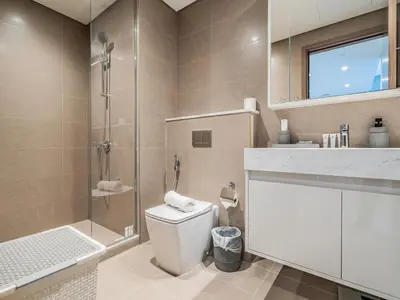 a bathroom with a toilet and a glass shower at Pleasant 1BR in Burj Royale - Downtown Dubai in Dubai