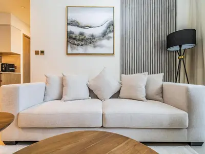 a living room with a white couch and a table at Pleasant 1BR in Burj Royale - Downtown Dubai in Dubai