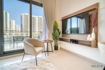 a living room with a tv and a chair at Sleek Studio at UNA Town Square Dubailand by Deluxe Holiday Homes in Dubai