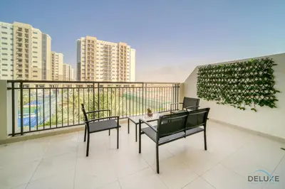 a balcony with a table and chairs on a building at Sleek Studio at UNA Town Square Dubailand by Deluxe Holiday Homes in Dubai