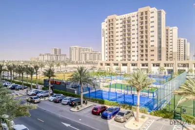 a parking lot in front of a large building at Sleek Studio at UNA Town Square Dubailand by Deluxe Holiday Homes in Dubai