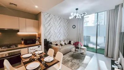 a kitchen and living room with a table and a couch at STAY BY LATINEM Luxury 1BR Holiday Home CV A103 near Burj Khalifa in Dubai