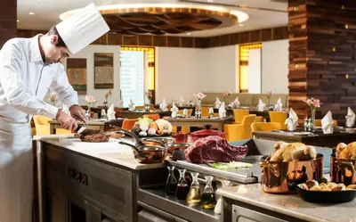 a chef preparing food in a restaurant kitchen at Carlton Downtown Hotel in Dubai