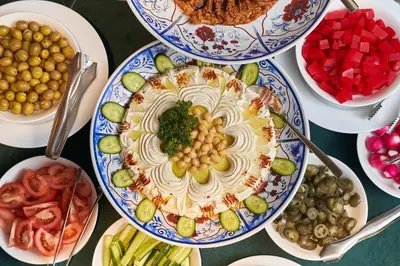 a table full of plates of food with vegetables at Carlton Downtown Hotel in Dubai