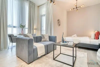 a living room with a couch and a table at Polished Studio at Mesk 1 Midtown Dubai Production City by Deluxe Holiday Homes in Dubai