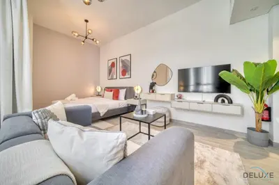 a living room with a couch and a bed at Polished Studio at Mesk 1 Midtown Dubai Production City by Deluxe Holiday Homes in Dubai