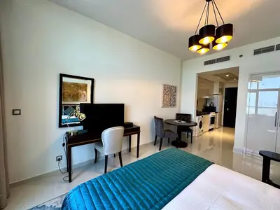 a bedroom with a bed and a desk with a computer at LuxBnB Studio Ghalia J V C in Dubai