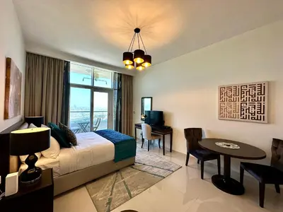 a bedroom with a bed and a desk and a table at LuxBnB Studio Ghalia J V C in Dubai