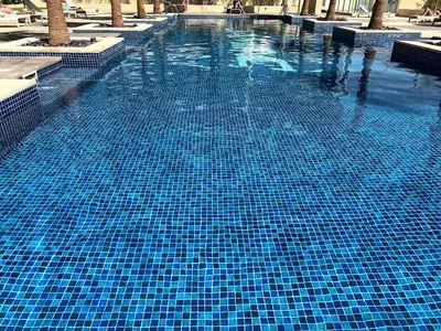 a large blue swimming pool with blue tiles at LuxBnB Studio Ghalia J V C in Dubai