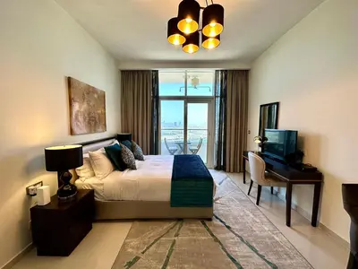 a bedroom with a bed and a desk and a television at LuxBnB Studio Ghalia J V C in Dubai