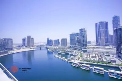 a river with boats in a city with tall buildings at Alashrafia Saray- Wonderous Studio in Canal Views in Dubai