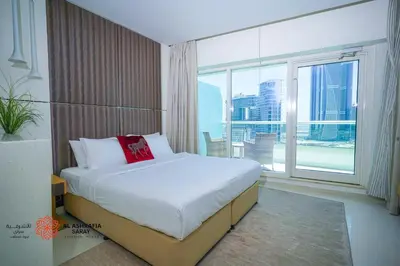 a bedroom with a large bed and a large window at Alashrafia Saray- Wonderous Studio in Canal Views in Dubai