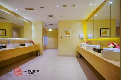 a bathroom with a row of sinks and mirrors at Alashrafia Saray- Wonderous Studio in Canal Views in Dubai