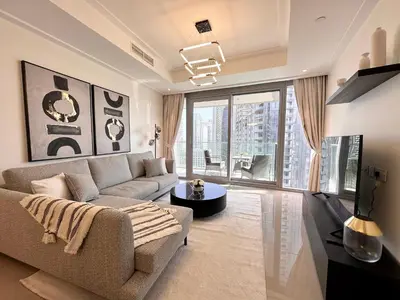 a living room with a couch and a large window at Opera Grand by Luxstay Holiday Homes in Dubai