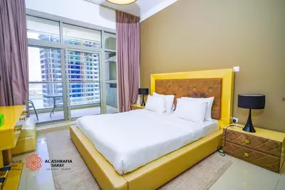 a bedroom with a bed and a large window at Alashrafia Saray- Homey 1BR apartment in Sport City in Dubai