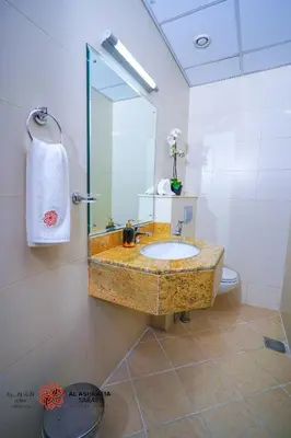 a bathroom with a sink and a mirror at Alashrafia Saray- Homey 1BR apartment in Sport City in Dubai