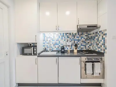a kitchen with white cabinets and a stove at Paradise Studio in Palm Views - Palm Jumeirah in Dubai