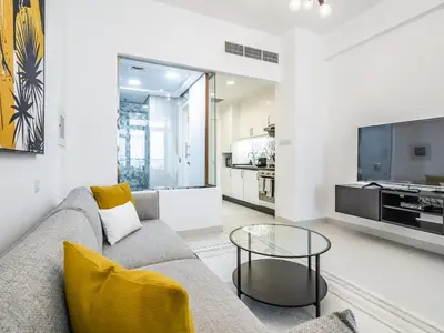 a living room with a couch and a glass table at Paradise Studio in Palm Views - Palm Jumeirah in Dubai