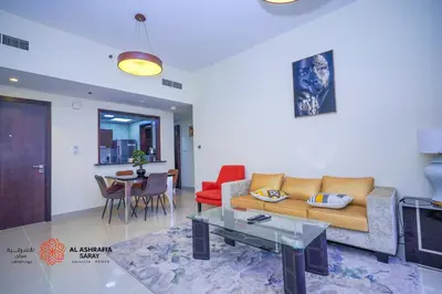 a living room with a couch and a table at Alashrafia Saray- Superior 1BR apartment in Sport City in Dubai