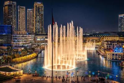 a fountain in the water in a city at night at Elite Royal Apartment Full Burj Khalifa & Fountain View - Czar in Dubai