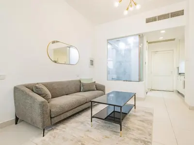 a living room with a couch and a table at Minimalistic Studio in Palm Views - Palm Jumeirah in Dubai