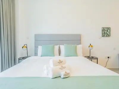 a bedroom with a large white bed with two towels at Minimalistic Studio in Palm Views - Palm Jumeirah in Dubai