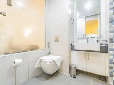 a white bathroom with a toilet and a sink at Minimalistic Studio in Palm Views - Palm Jumeirah in Dubai