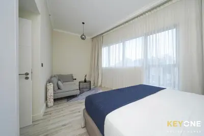 a bedroom with a bed and a couch and a large window at Chic Marina View Living in a Two Bedroom in Dubai