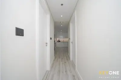 an empty hallway with white walls and wood floors at Chic Marina View Living in a Two Bedroom in Dubai