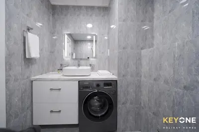 a bathroom with a washing machine and a sink at Chic Marina View Living in a Two Bedroom in Dubai
