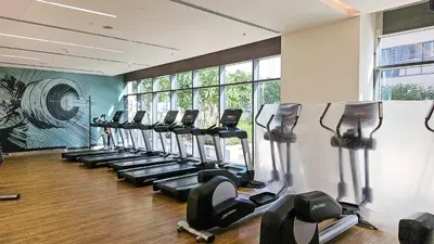 a gym with a row of treadmills at CitiHome- Modern- 1BR Creek Residence in Dubai