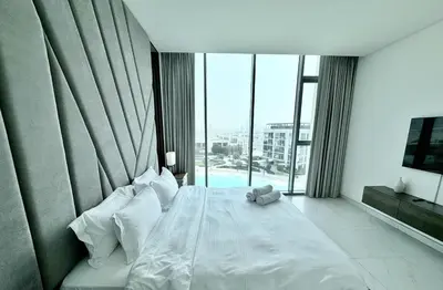 a bedroom with a white bed with a large window at Panoramic 1br with Crystal Lagoon & Downtown View in Dubai