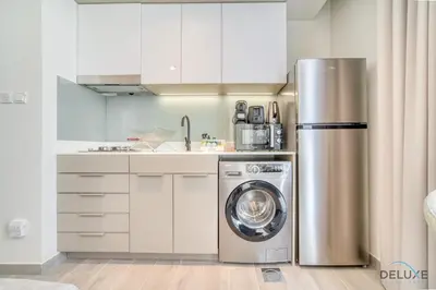 a kitchen with a stainless steel refrigerator and a dishwasher at Graceful Studio at Mesk 1 Midtown Dubai Production City by Deluxe Holiday Homes in Dubai