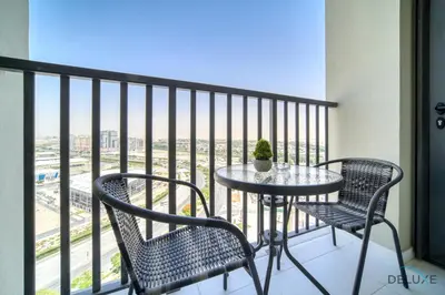 a table and chairs on a balcony with a view at Classic Studio at Mesk 1 Midtown Dubai Production City by Deluxe Holiday Homes in Dubai